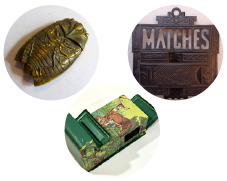 three match holders, one shaped like a cicada, one green and yellow with a deer, one cast iron with the word matches